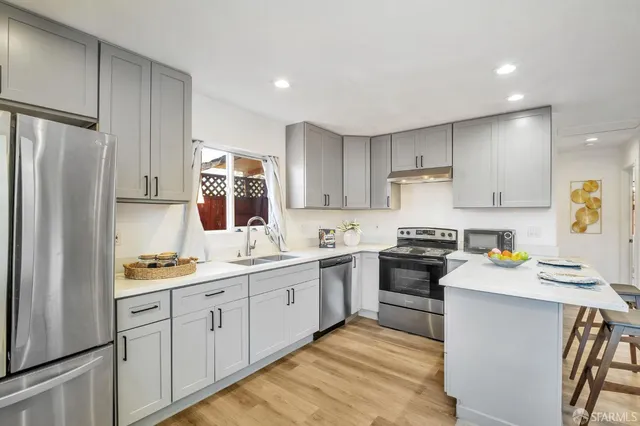 a kitchen with a sink a refrigerator and white cabinets