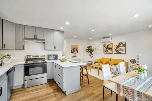 a kitchen with stainless steel appliances granite countertop a stove and white cabinets