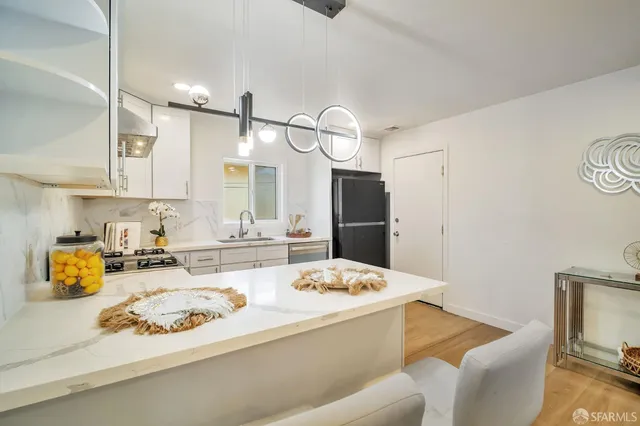 a kitchen with stainless steel appliances kitchen island granite countertop a sink and refrigerator