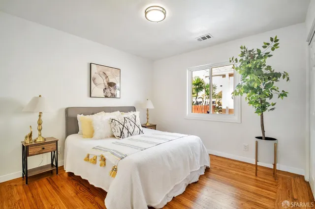 a bedroom with bed and a potted plant