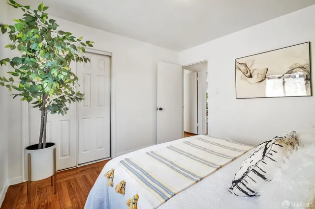 a bedroom with a bed and a plant