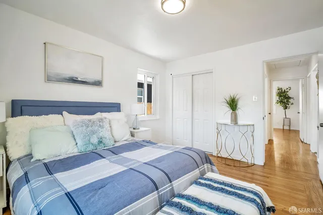 a bedroom with a bed and painting on the wall