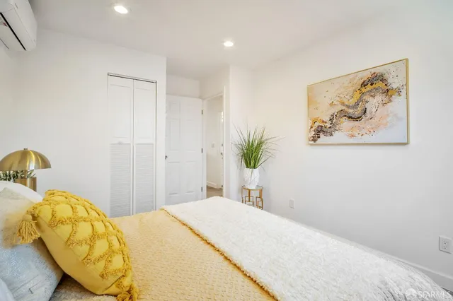 a bedroom with a bed and painting on the wall