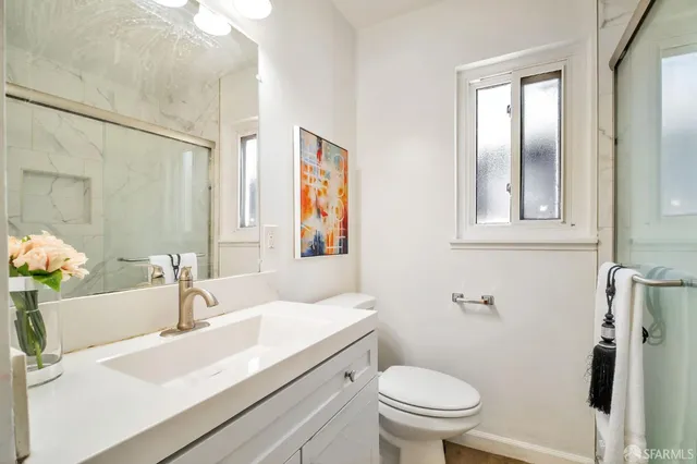 a bathroom with a sink a toilet and shower