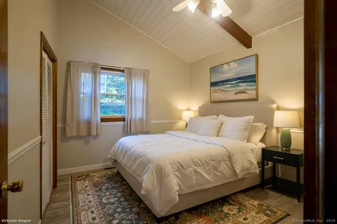 a bedroom with a bed and a lamp on dresser