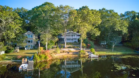 a backyard of a house with large trees and plants