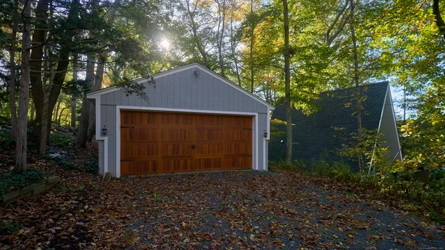 a front view of a house with a yard and tree s
