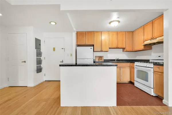 a kitchen with granite countertop a sink cabinets stainless steel appliances and a window