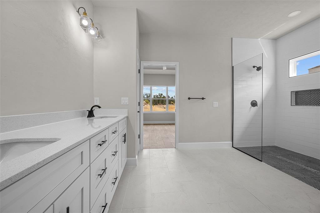 6694 Southwest 11th Lane Gainesville, FL 32607 - Photo 13 of 27 a bathroom with a double vanity sink a toilet and shower