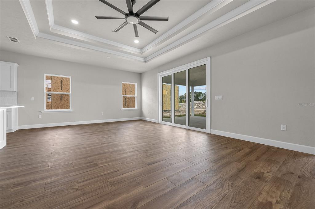 6694 Southwest 11th Lane Gainesville, FL 32607 - Photo 21 of 27 an empty room with wooden floor fan and windows