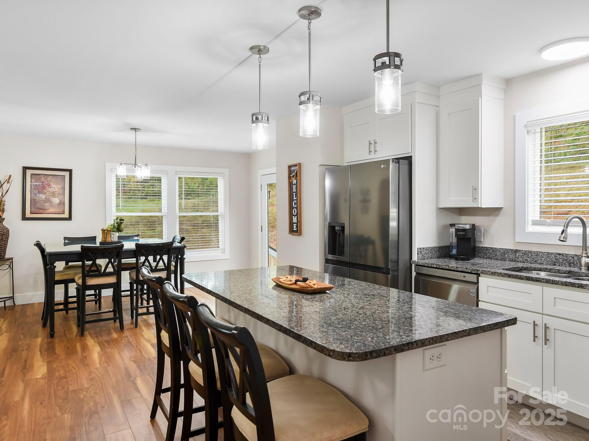 258 Old Weaverville Road Asheville, NC 28804 - Photo 11 of 25 a kitchen with stainless steel appliances granite countertop a dining table chairs stove refrigerator and wooden floor