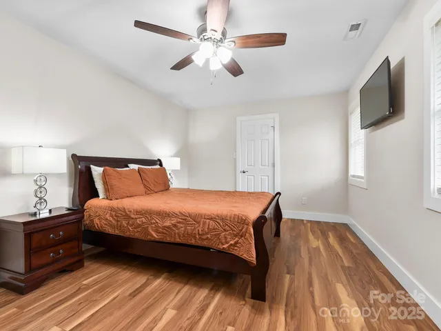 a bedroom with a bed and a flat tv screen on dresser