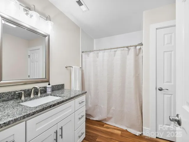 a bathroom with a granite countertop sink and a mirror