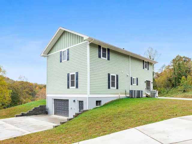 a front view of a house with a garden and yard