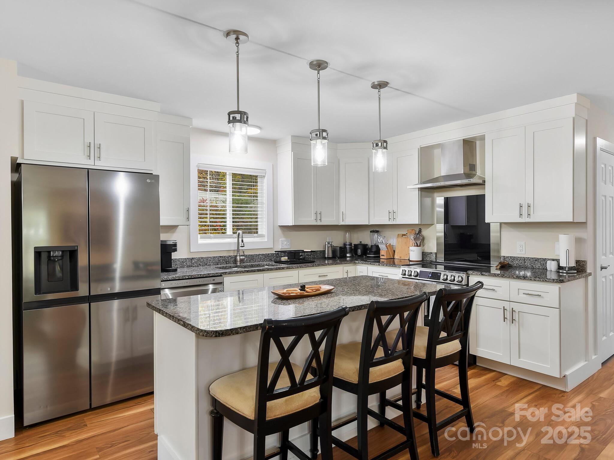 258 Old Weaverville Road Asheville, NC 28804 - Photo 9 of 25 a kitchen with stainless steel appliances granite countertop a sink a stove a refrigerator cabinets a dining table and chairs