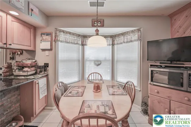 a kitchen with stainless steel appliances granite countertop a stove a refrigerator with a dining table and chairs