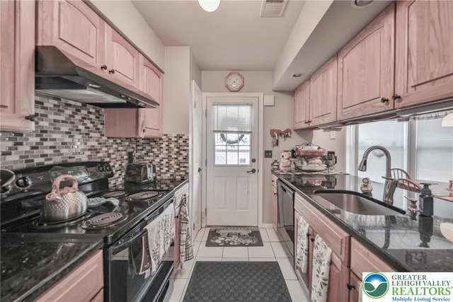 a kitchen with stainless steel appliances granite countertop a sink stove and cabinets