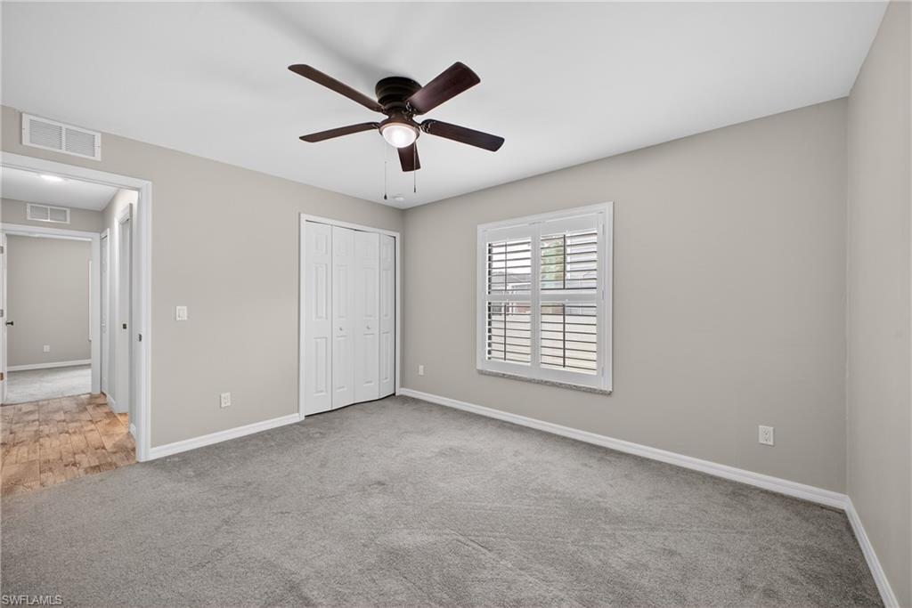 8422 Cardinal Road Fort Myers, FL 33967 - Photo 21 of 24 Unfurnished bedroom featuring ceiling fan, a closet, and carpet flooring