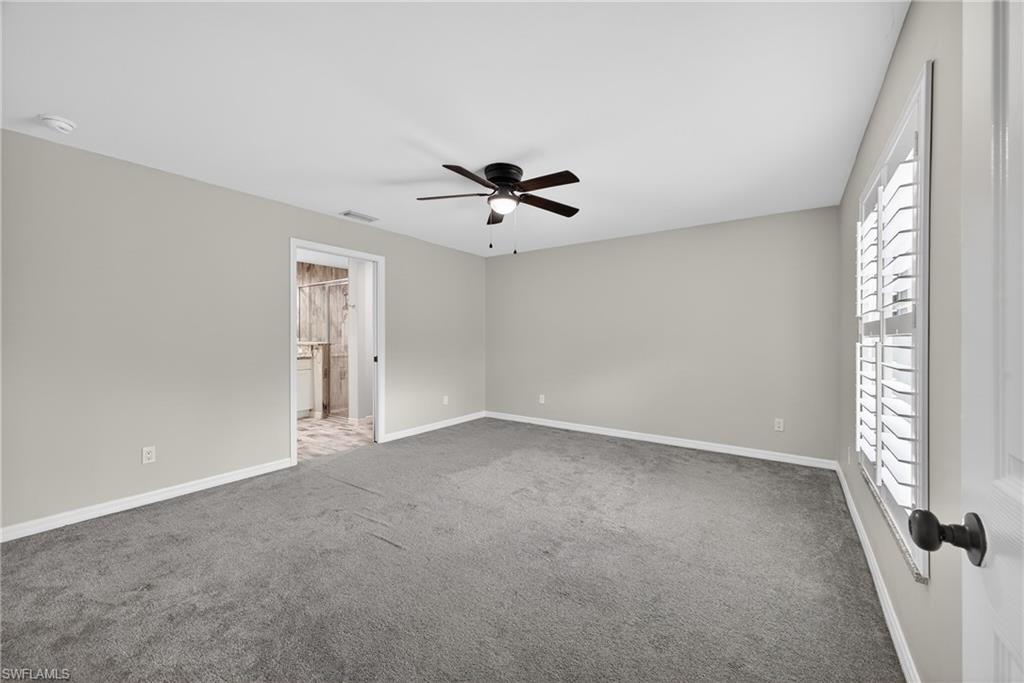 8422 Cardinal Road Fort Myers, FL 33967 - Photo 9 of 24 Unfurnished bedroom featuring light carpet, a ceiling fan, and connected bathroom
