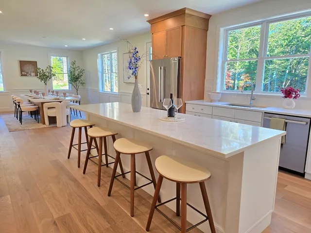 a kitchen with stainless steel appliances granite countertop a kitchen island a table and chairs in it