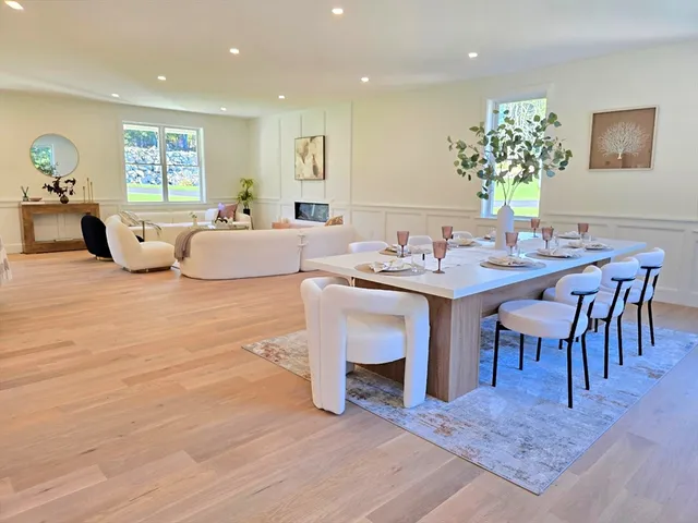 a living room with furniture a dining table and a potted plant