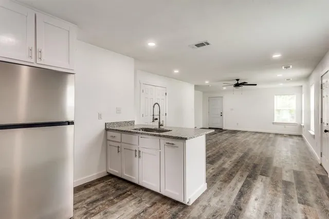 a kitchen with stainless steel appliances granite countertop a refrigerator a sink and a stove