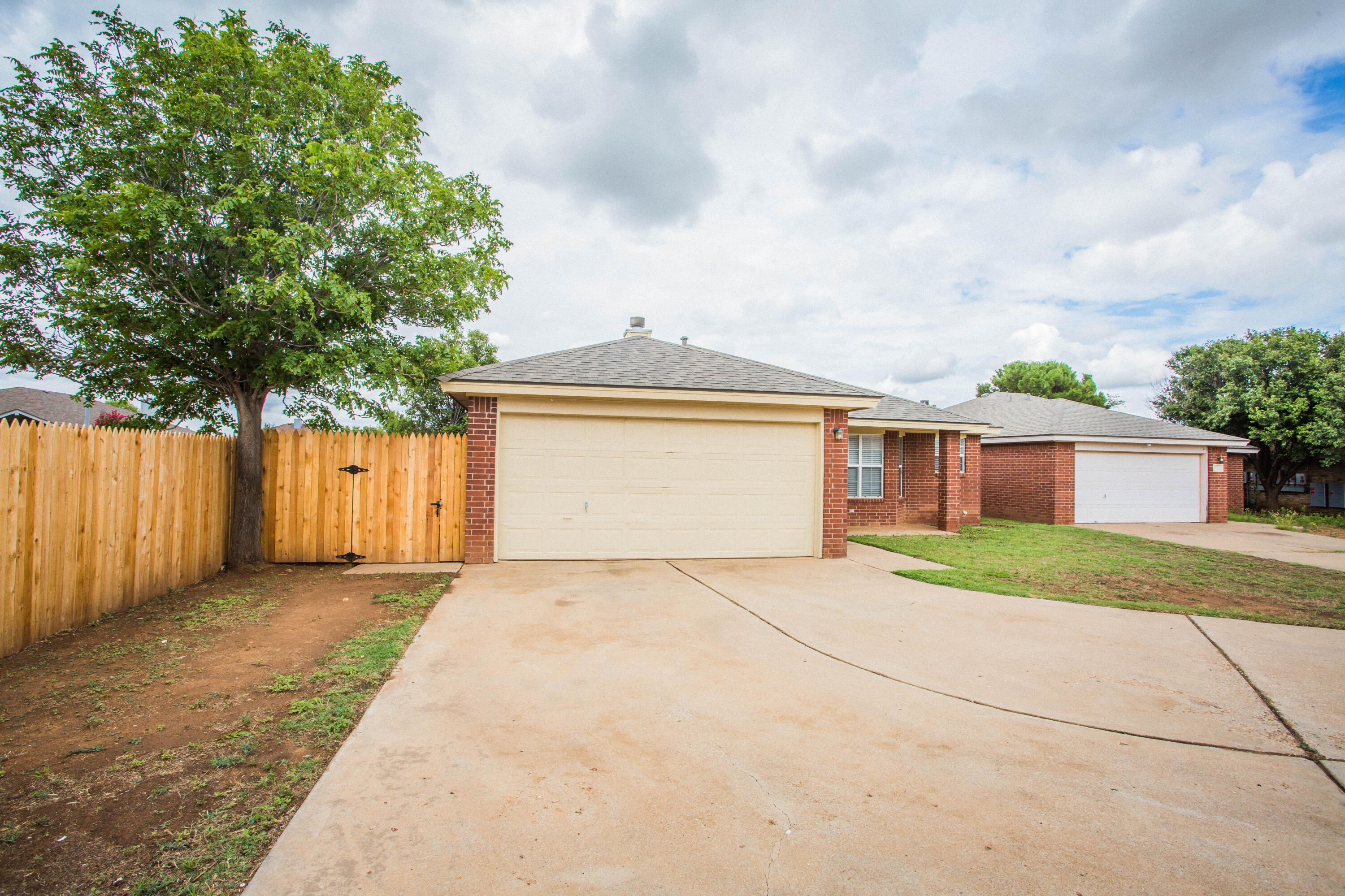 1822 79th Street Lubbock, TX 79423 - Photo 2 of 35 a front view of a house with a yard and garage
