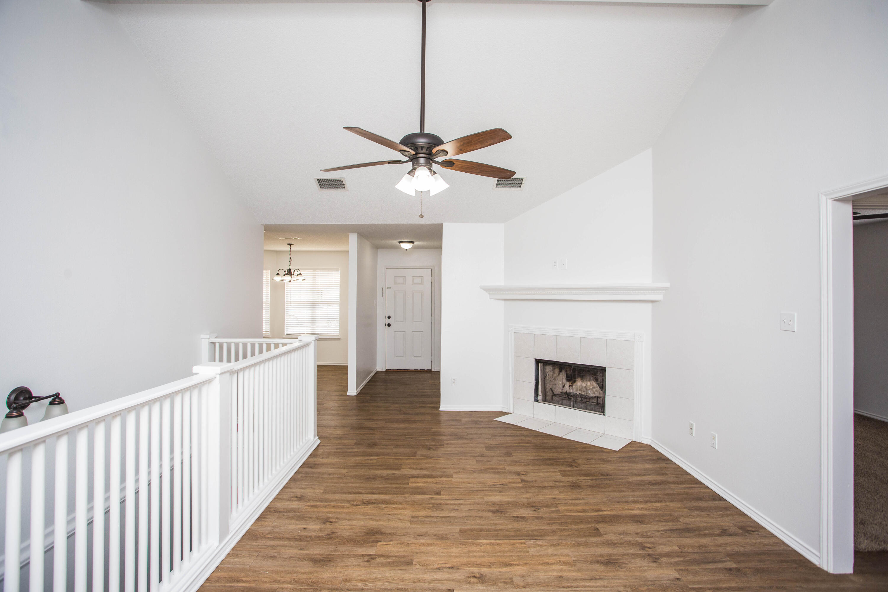 1822 79th Street Lubbock, TX 79423 - Photo 8 of 35 a view of an empty room with a fireplace and a chandelier fan