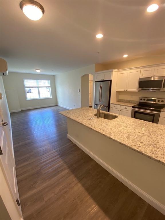 47 Saunders Street, Unit 47 North Andover, MA 01845 - Photo 4 of 11 a large kitchen with kitchen island granite countertop a sink window and stainless steel appliances