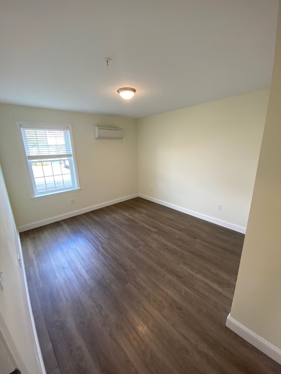 47 Saunders Street, Unit 47 North Andover, MA 01845 - Photo 9 of 11 an empty room with wooden floor and windows