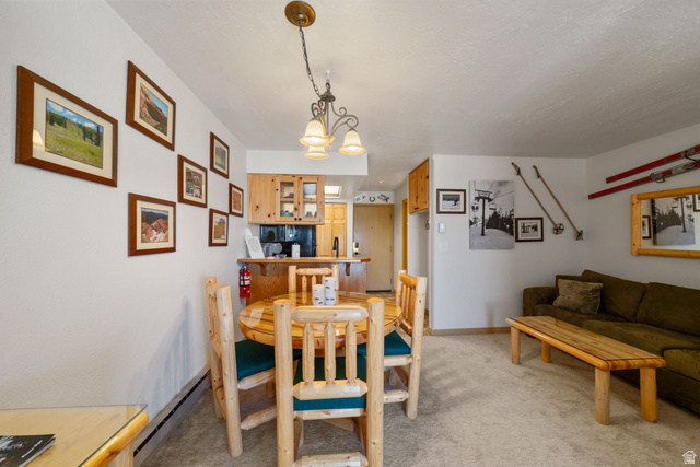 150 Ridgeview Street, Unit 117 Brian Head, UT 84719 - Photo 13 of 20 Dining area featuring light colored carpet, a baseboard heating unit, and a chandelier