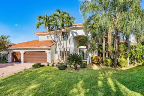 a front view of a house with a yard and potted plants