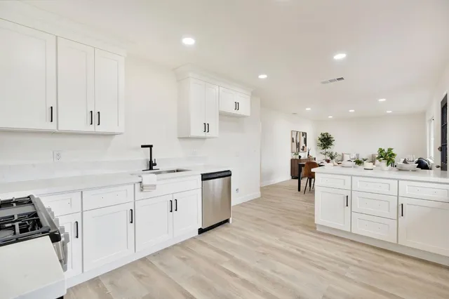 a kitchen with white cabinets and sink