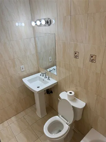 a bathroom with a sink toilet and a mirror