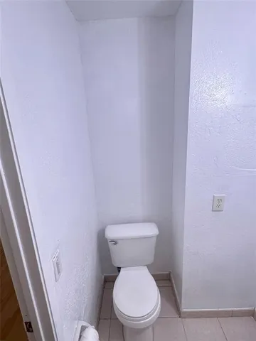 a white toilet sitting next to a shower
