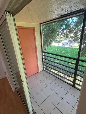 a view of a room with a large window and wooden floor