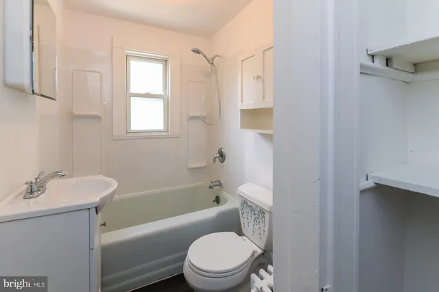 a white toilet sitting next to a bath tub