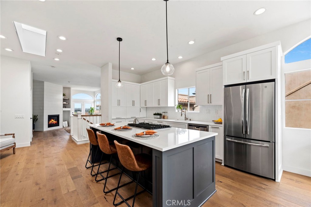 a kitchen with stainless steel appliances a dining table chairs stove and refrigerator