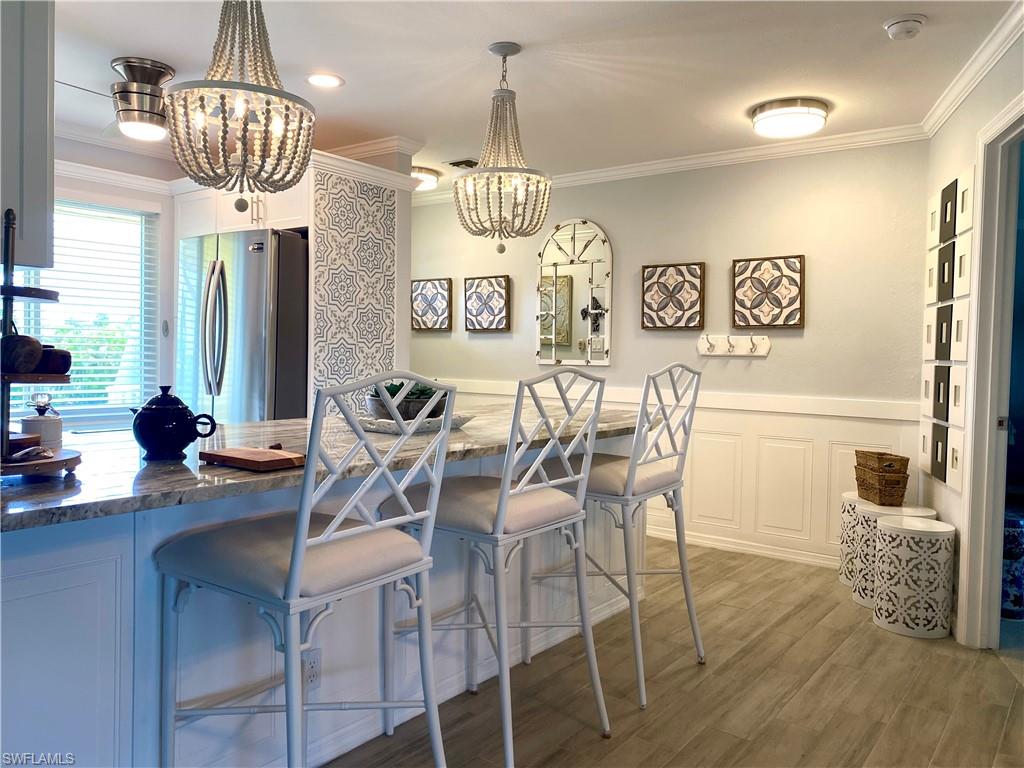 306 Palm Drive, Unit 2 Naples, FL 34112 - Photo 1 of 25 a view of a dining room with furniture a chandelier and wooden floor