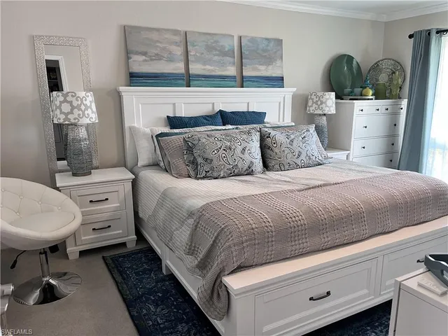 a spacious bedroom with a bed a dresser and potted plant on the dresser