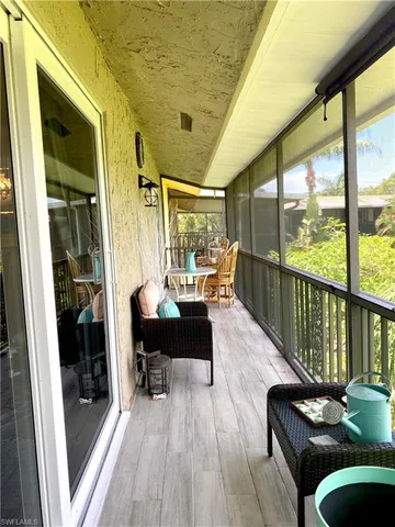 a living room with furniture floor to ceiling window and wooden floor