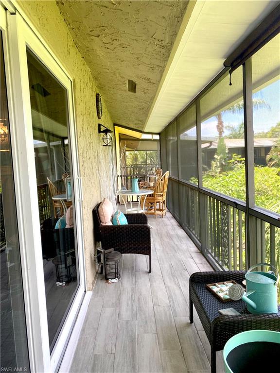 306 Palm Drive, Unit 2 Naples, FL 34112 - Photo 16 of 25 a living room with furniture floor to ceiling window and wooden floor