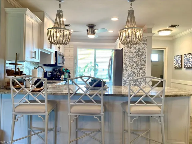 a view of a dining room with furniture a chandelier and wooden floor