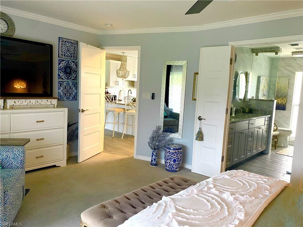 306 Palm Drive, Unit 2 Naples, FL 34112 - Photo 8 of 25 a bedroom with a bed and flat screen tv