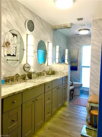 a bathroom with a granite countertop sink and a mirror