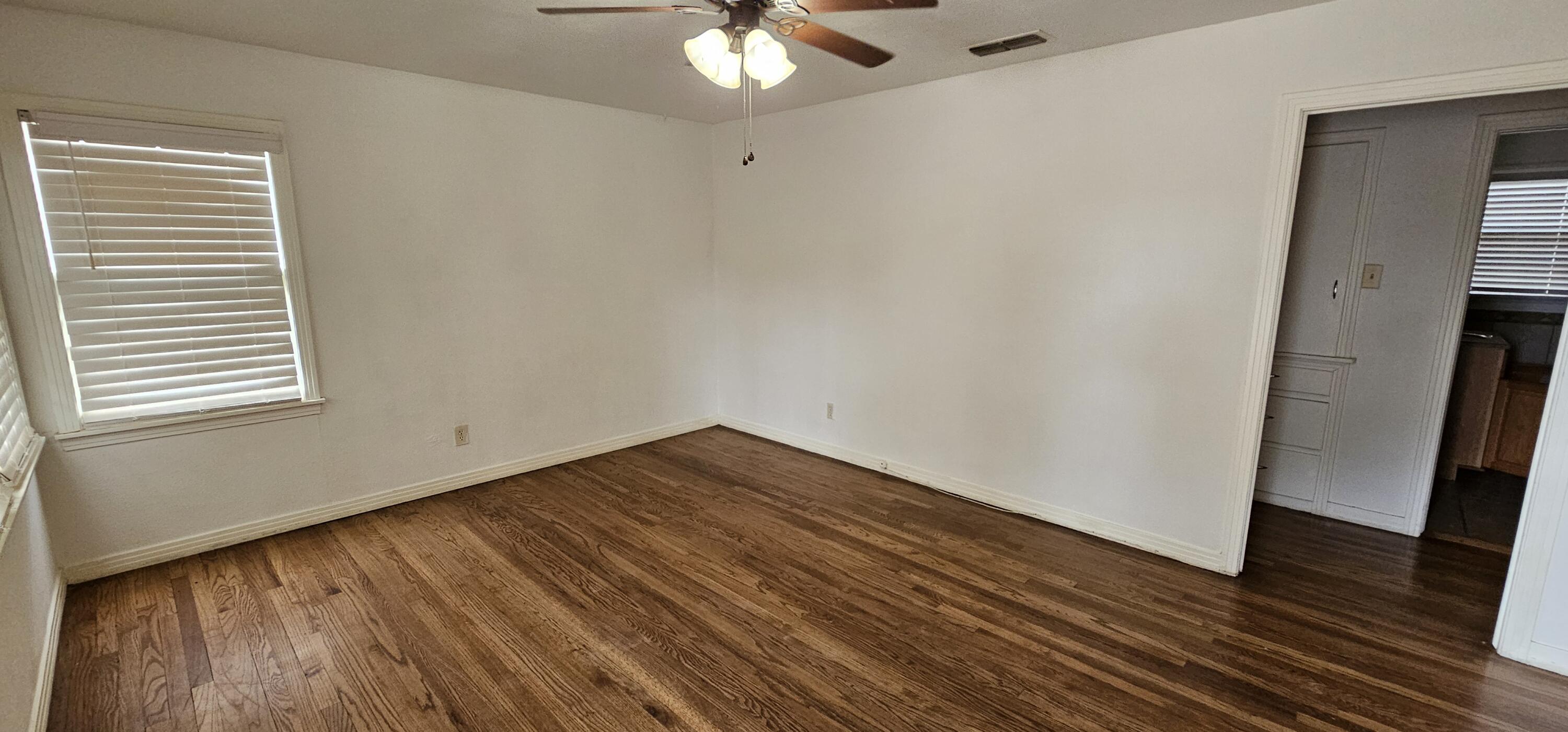 2007 62nd Street Lubbock, TX 79412 - Photo 2 of 17 a view of an empty room with wooden floor and a window