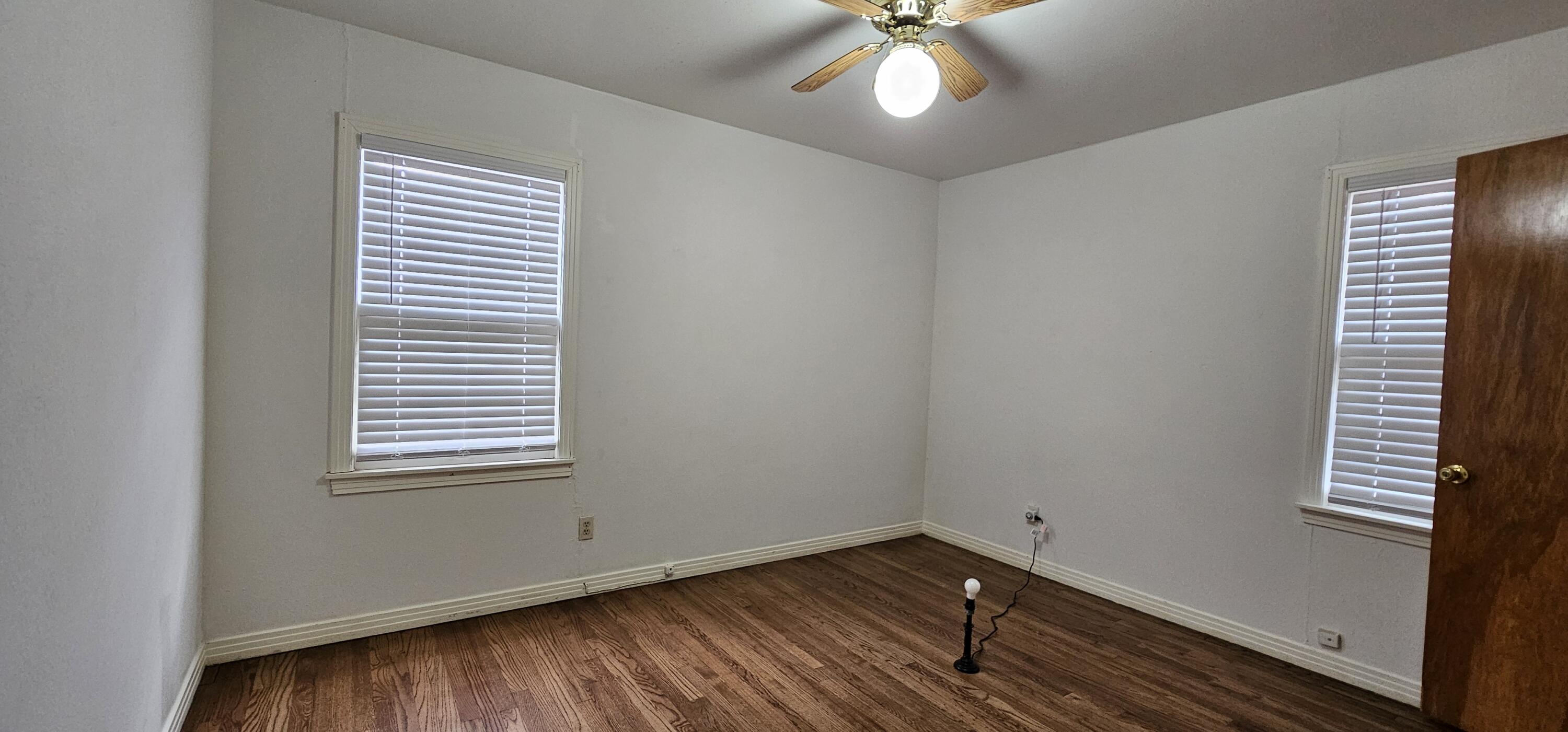 2007 62nd Street Lubbock, TX 79412 - Photo 3 of 17 an empty room with wooden floor and windows