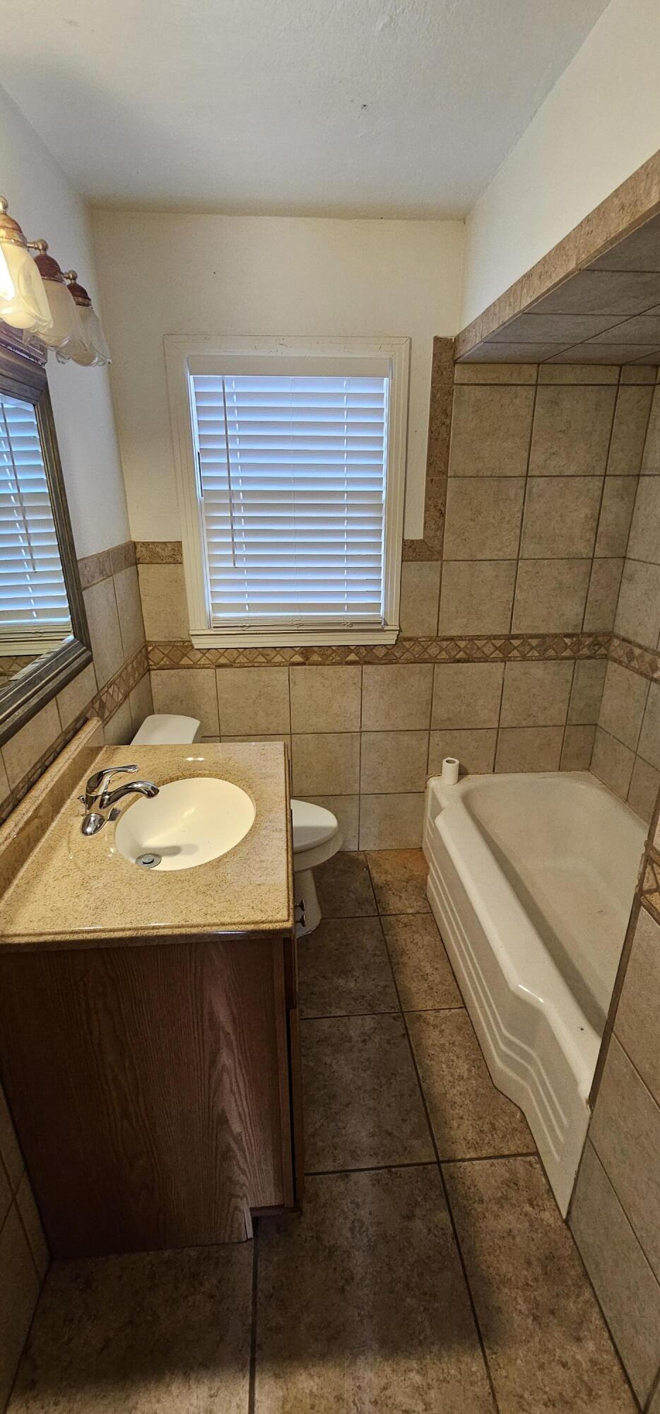 2007 62nd Street Lubbock, TX 79412 - Photo 4 of 17 a bathroom with a sink a toilet and mirror