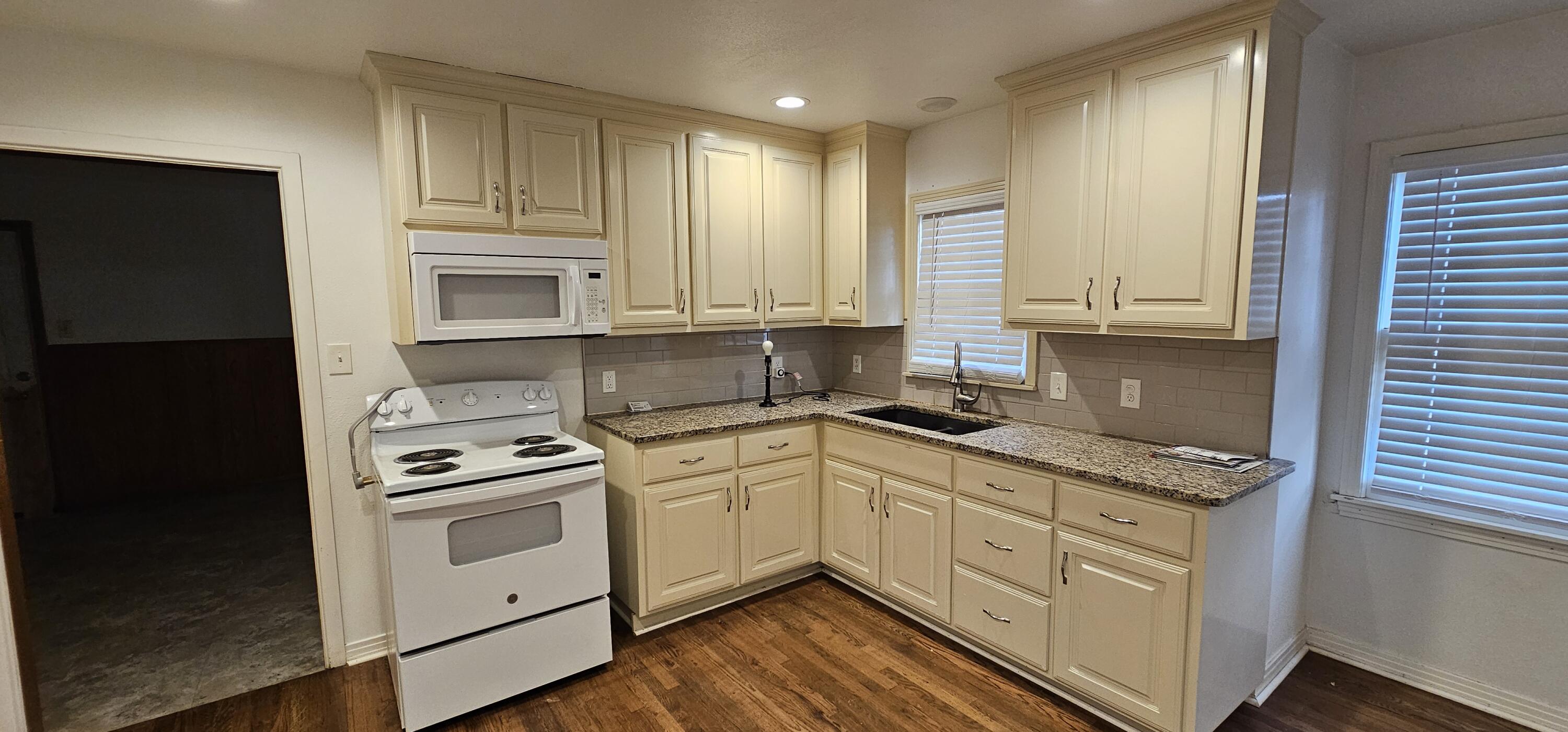 2007 62nd Street Lubbock, TX 79412 - Photo 9 of 17 a kitchen with stainless steel appliances granite countertop a sink stove and refrigerator