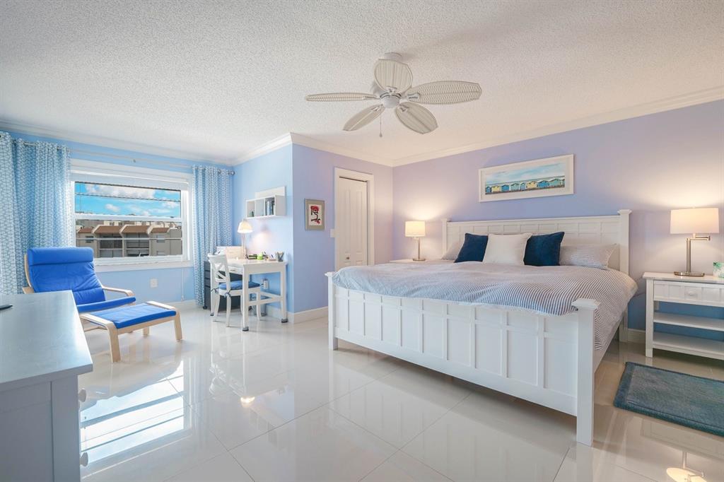 3930 Inverrary Boulevard, Unit 603D Lauderhill, FL 33319 - Photo 24 of 74 a bedroom with a large bed and a chandelier